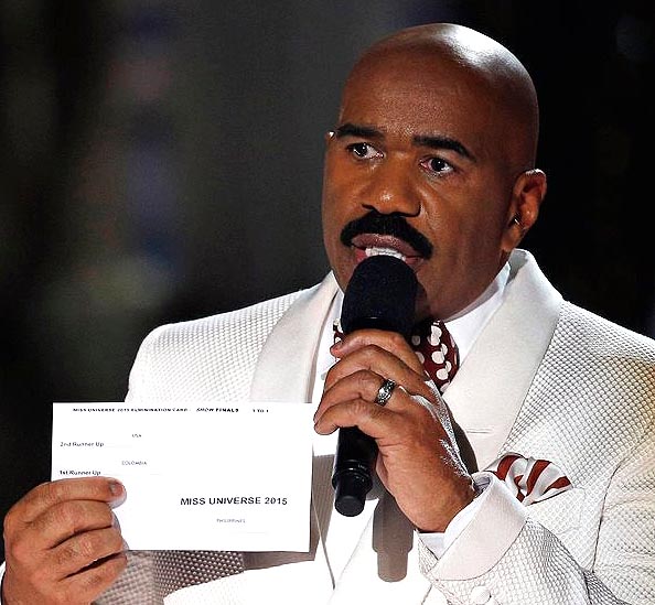 Host Steve Harvey shows card with results